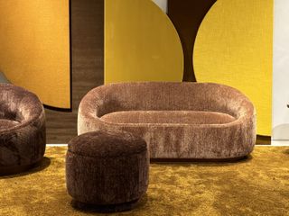 An orangey-brown chenille sofa with a brown chenille sofa seater and poufsof