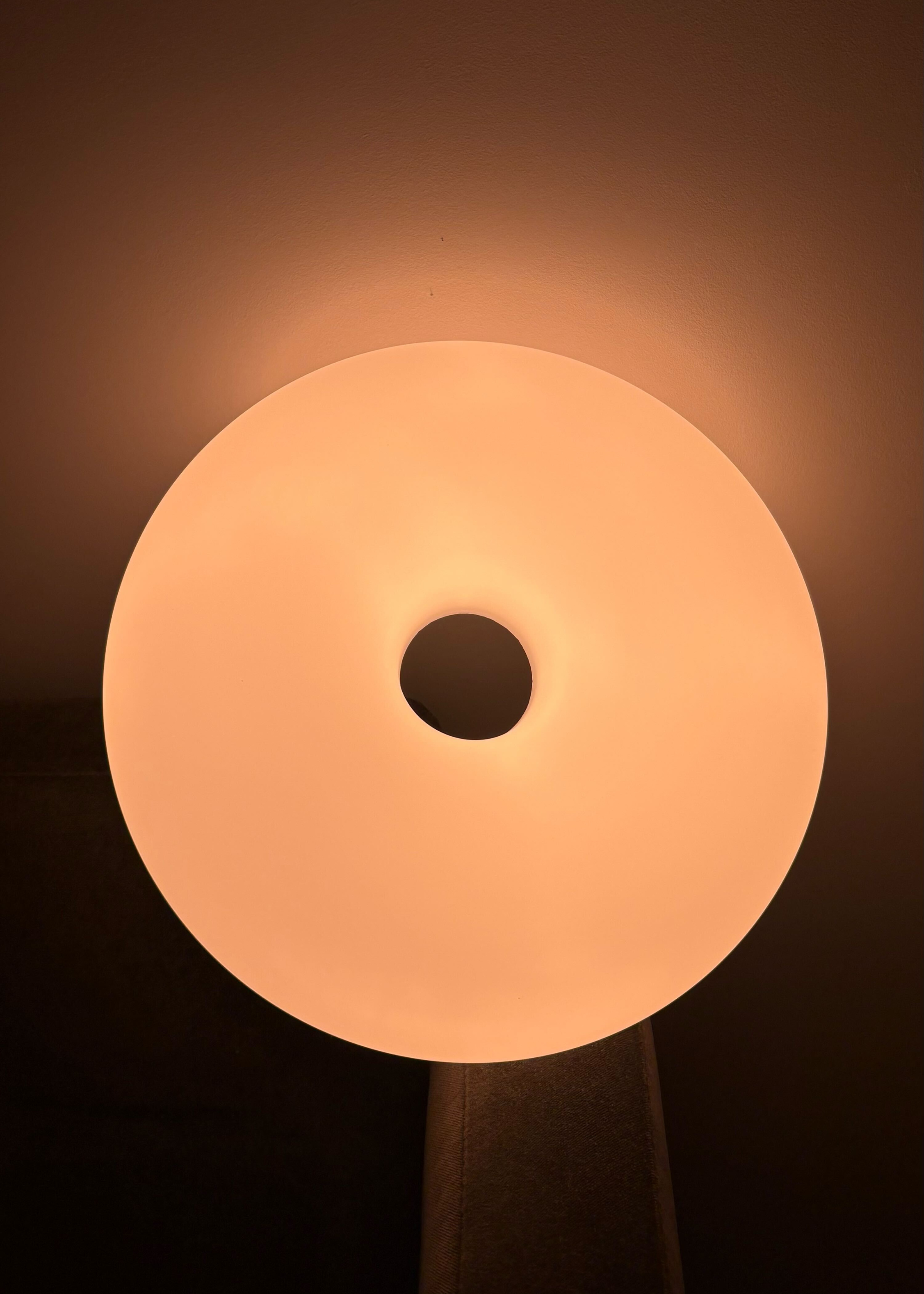 The IKEA VARMBLIXT donut lamp reflecting yellow light