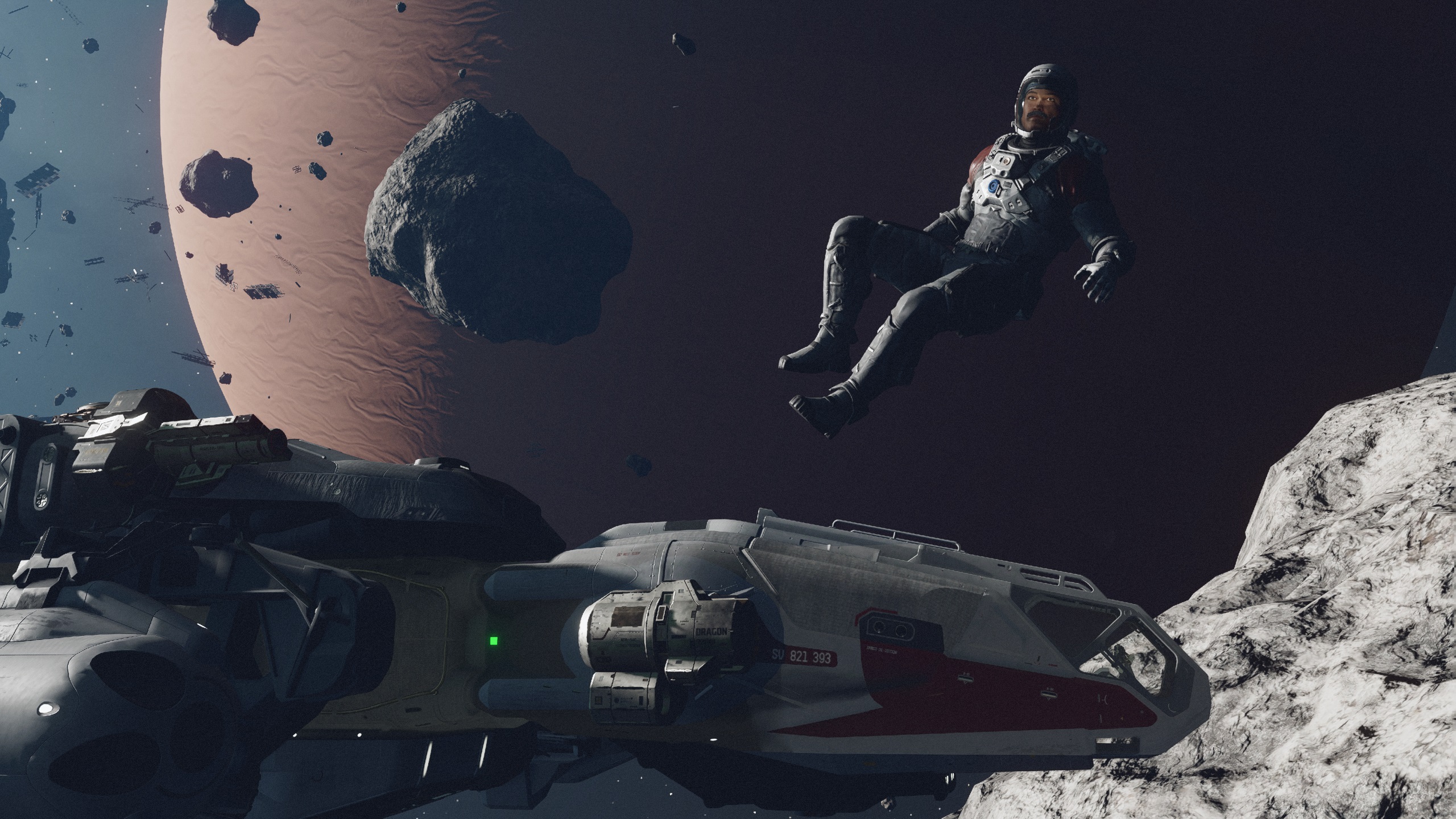 Starfield character in space suit floating amid asteroid field above gas giant