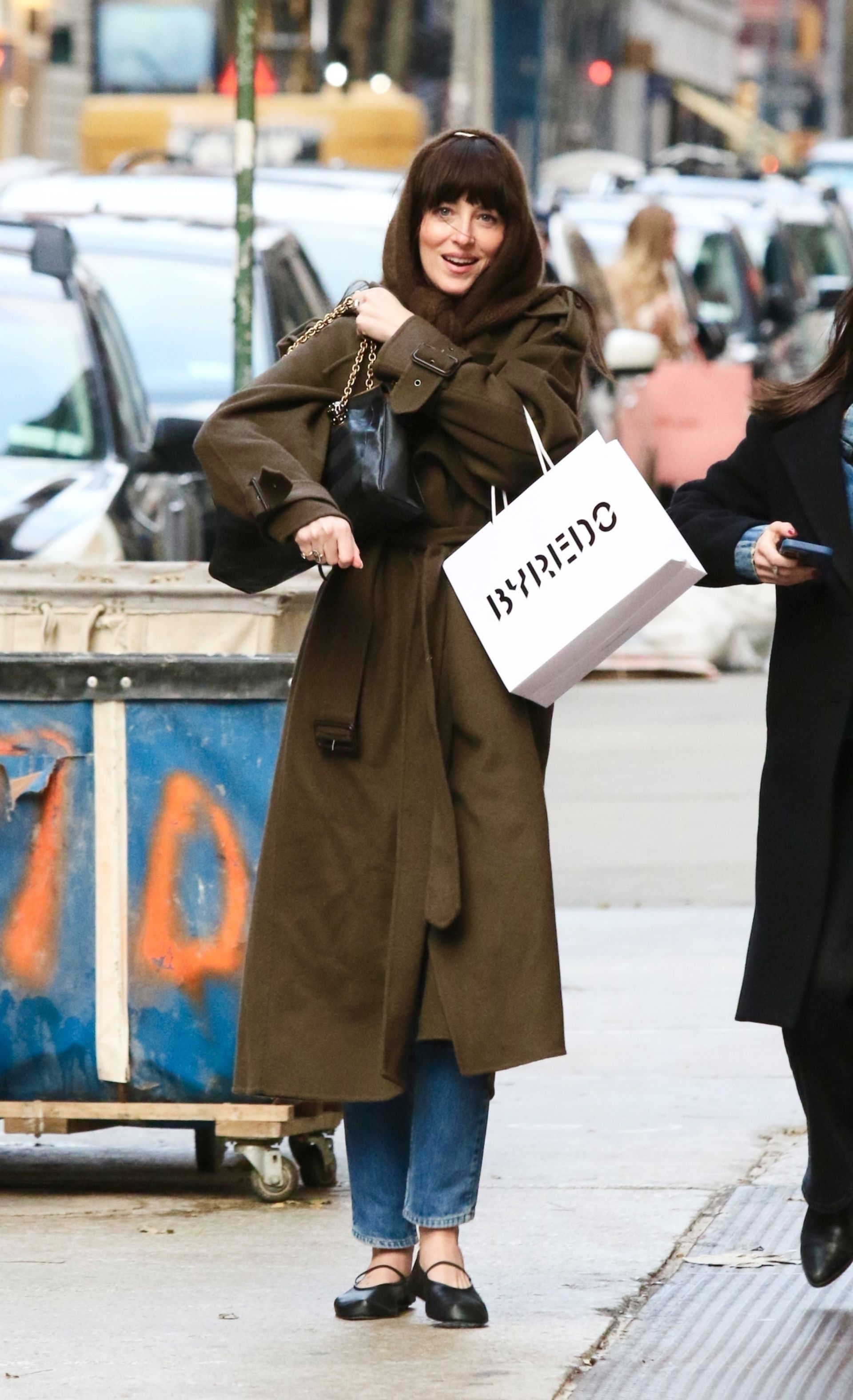 Dakota Johnson sports a stylish wardrobe with a headscarf while shopping in NYC.