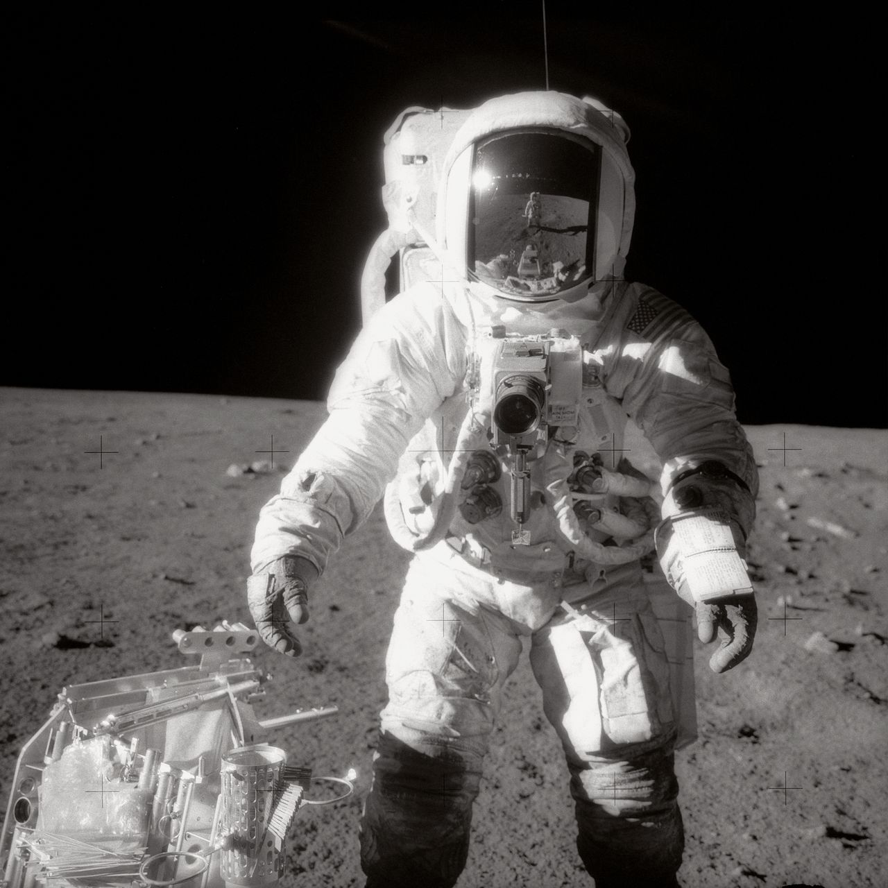 Astronaut Alan L. Bean, Apollo 12, walks on the Moon's surface. Commander Charles Conrad Jr. is reflected in Bean's helmet visor.