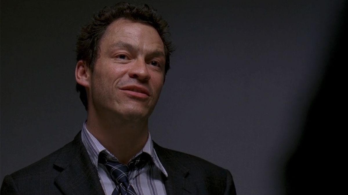 Dominic West as McNulty in The Wire, wearing a suit with his tie down and smirking in The Wire