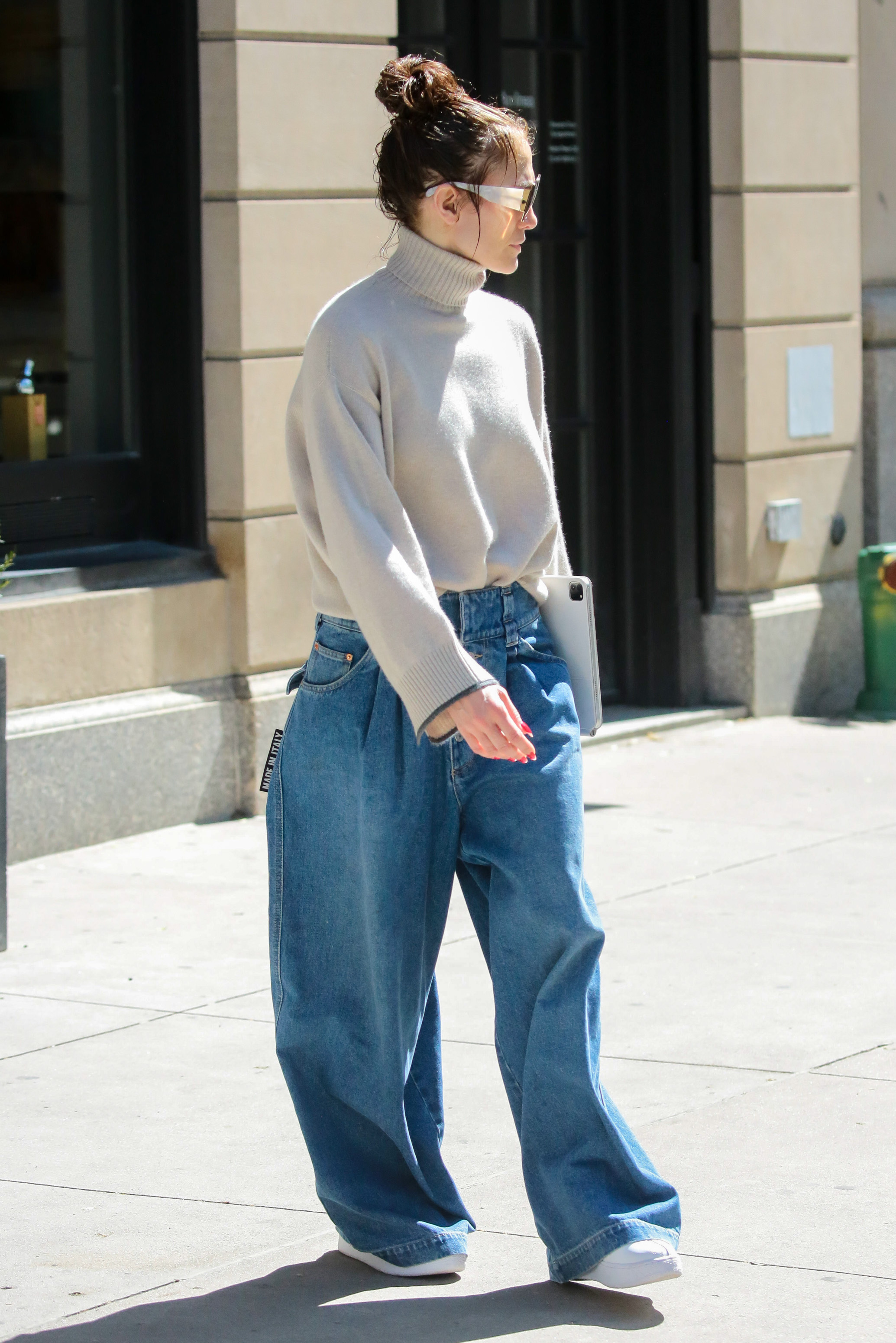 Jennifer Lopez wearing baggy, wide-leg jeans with white platform sneakers.