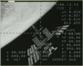 This view of the space shuttle Endeavour (bottom right) docked at the International Space Station shows the two spacecraft in the docking camera on a Russian Soyuz spacecraft as it backed away from the orbiting lab on May 23, 2011 during the final flight of Endeavour, STS-134.
