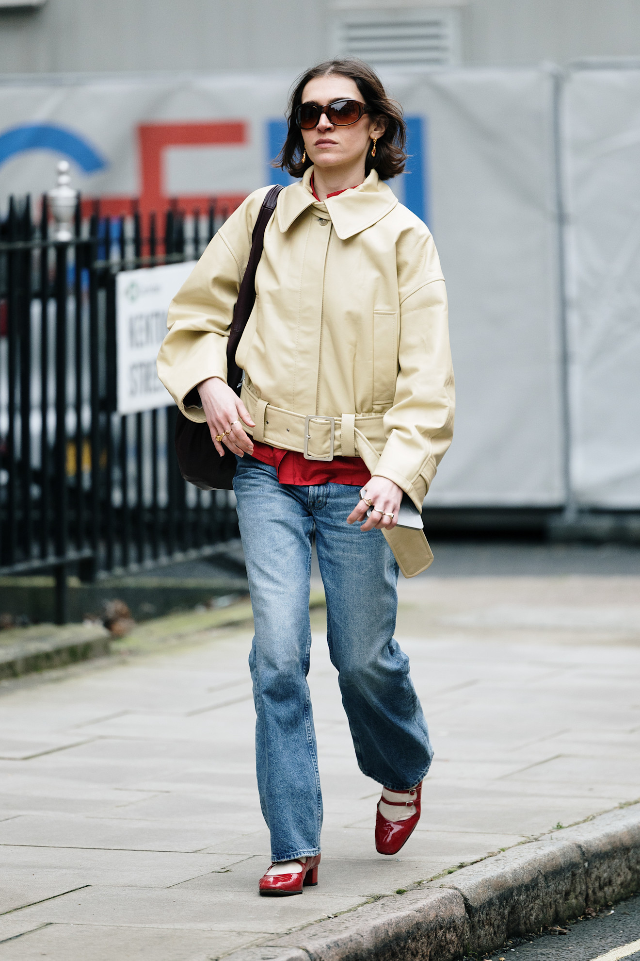 fashion week attendee wearing sunglasses, short trench coat, jeans