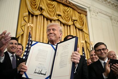 US President Donald Trump displays the GENIUS Act