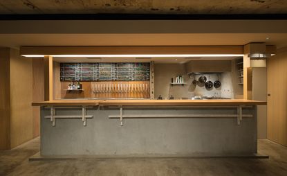 Bar with solid wood top, floors and walls of exposed concrete