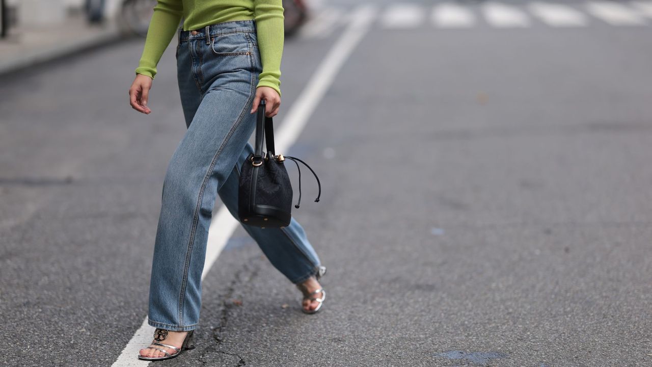 Woman crossing the street in New York wearing casual jeans, an outfit fitting for an unpretentious perfume