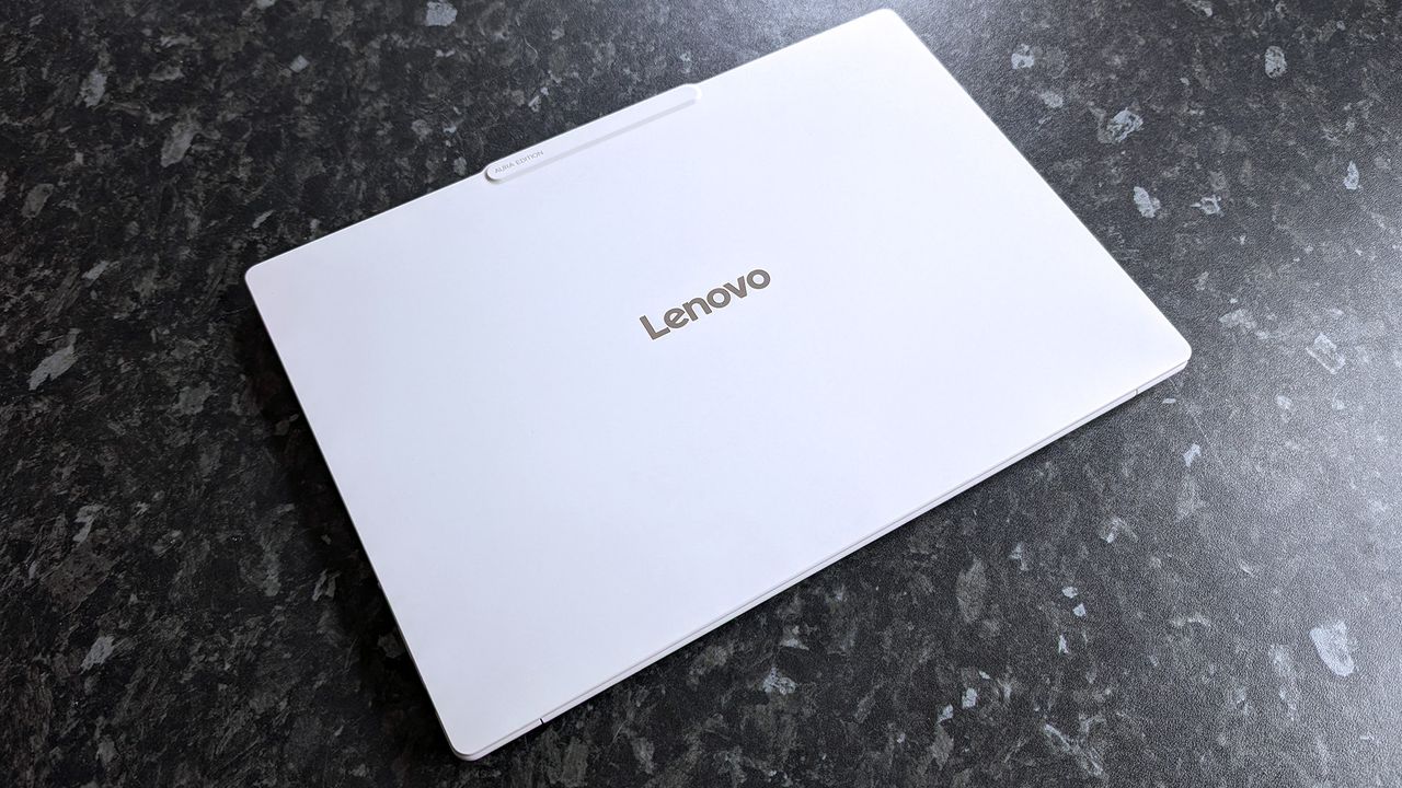 Closed Lenovo Yoga Slim 7i Ultra (Gen 11) Aura Edition laptop on a dark marbled surface. The Lenovo logo is centered on the lid.