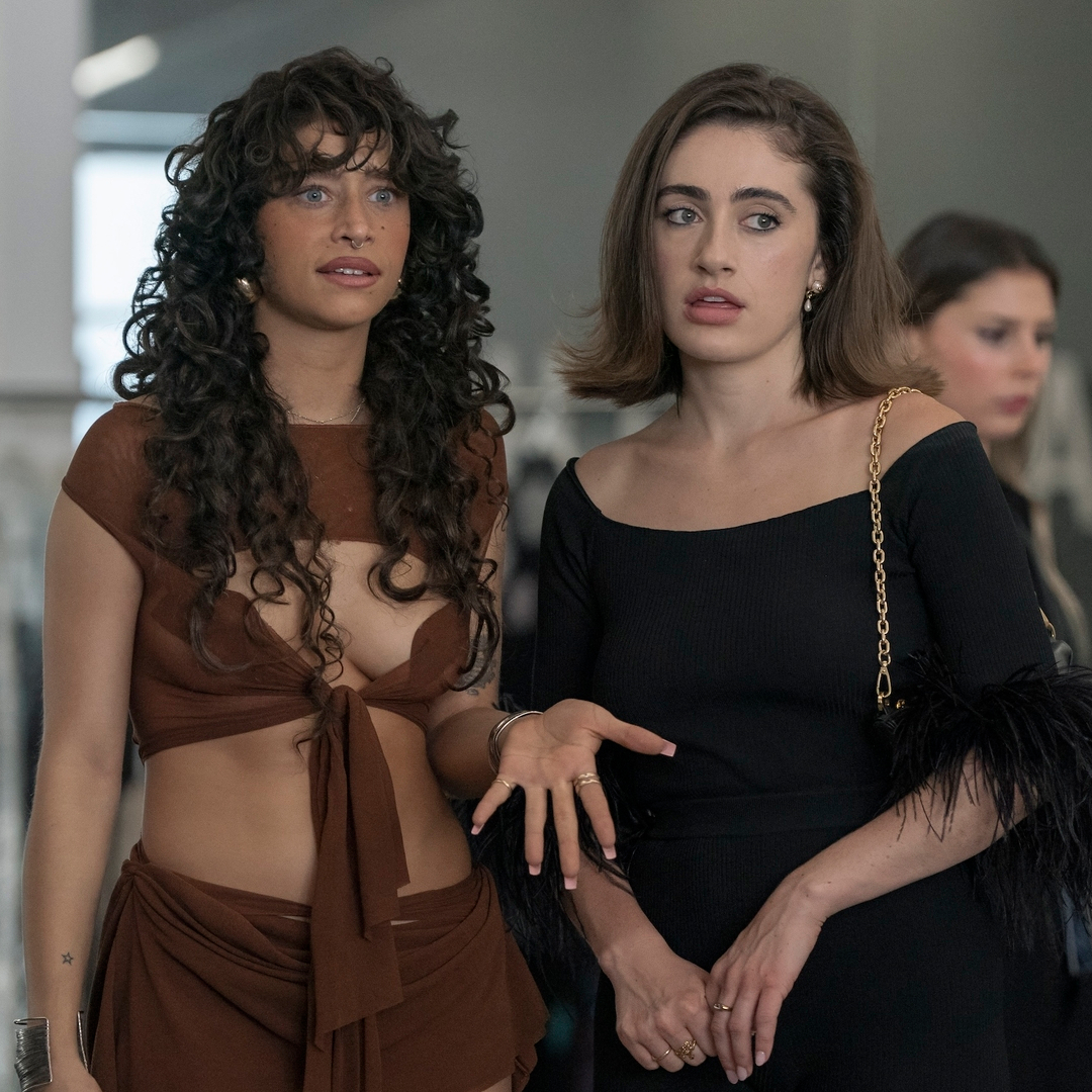 odessa a'zion as tallulah wearing a brown cut out set and rachel sennott as maia wearing a black feather top in an office for a fashion designer in a still from the i love la season 1 finale