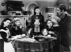 actors Margaret O'Brien, Elizabeth Taylor, June Allyson, Janet Leigh, and Peter Lawford sit around a table having tea, in a still from director Mervyn LeRoy's film, 'Little Women