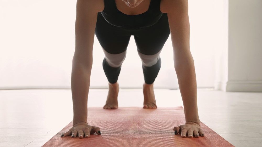 a photo of a woman doing a plank jack