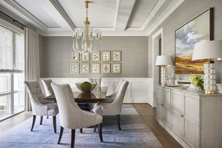 grey dining room with white wall paneling and a sideboard