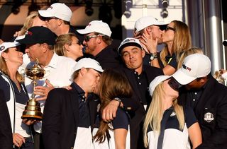 Rickie Fowler at the 2016 Ryder Cup as the players and wives kiss around him