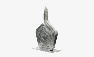 Artistic model metal sculpture of the Empire states building on a metal stand, white background