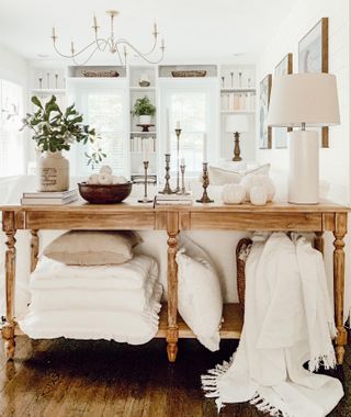 White fall display on console with cushions, pumpkins and throws