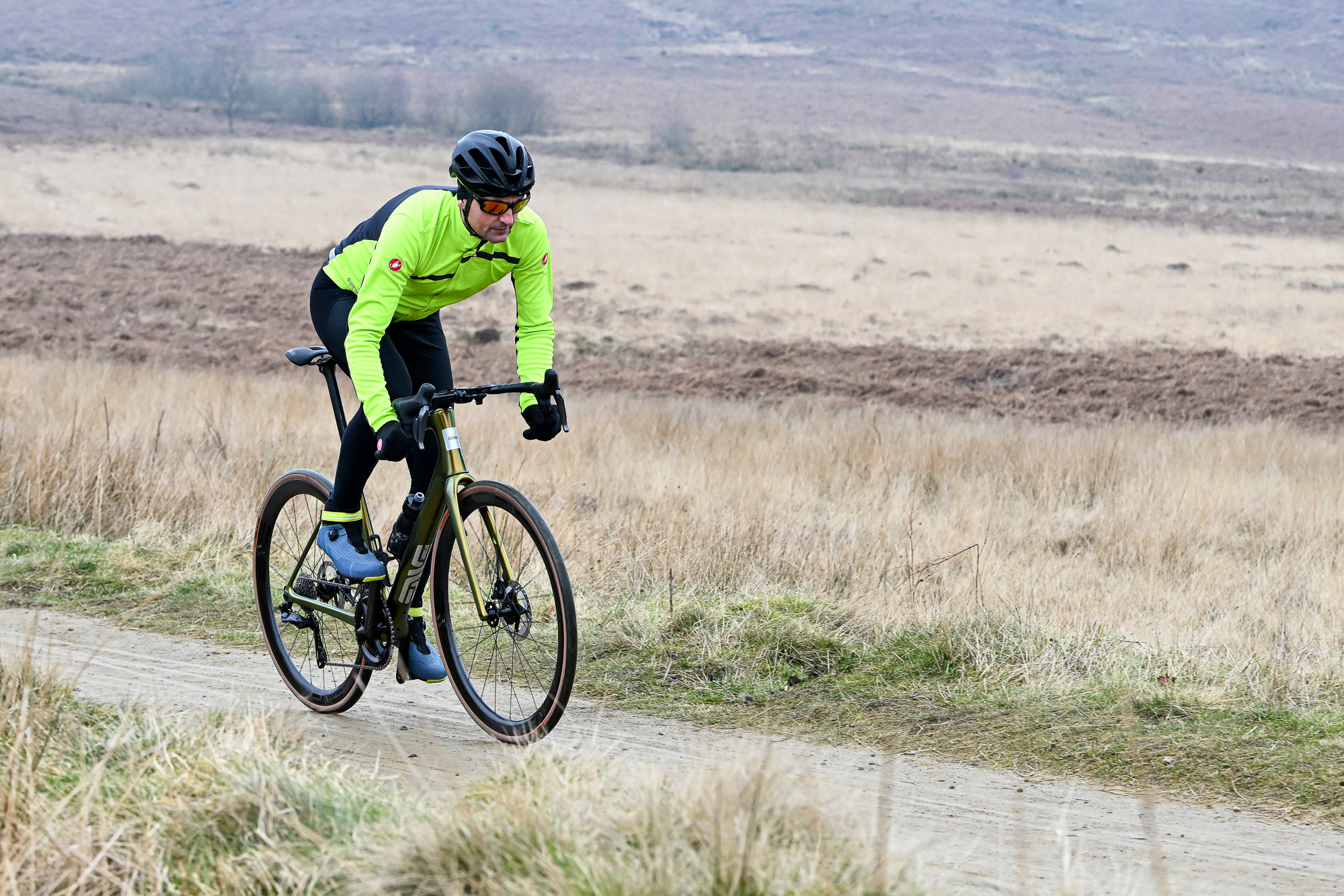 Man riding an ENVE Fray bike out of the saddle on a sandy trail