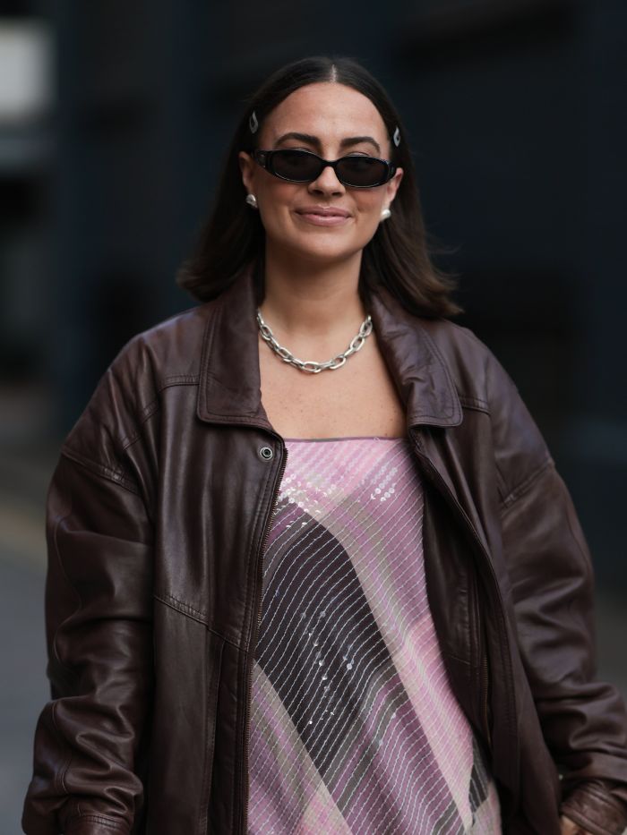 A woman at London Fashion Week with a lob hairstyle wearing a brown leather jacket