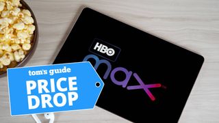 A tablet with HBO Max onscreen next to a bowl of popcorn and AirPods Pro