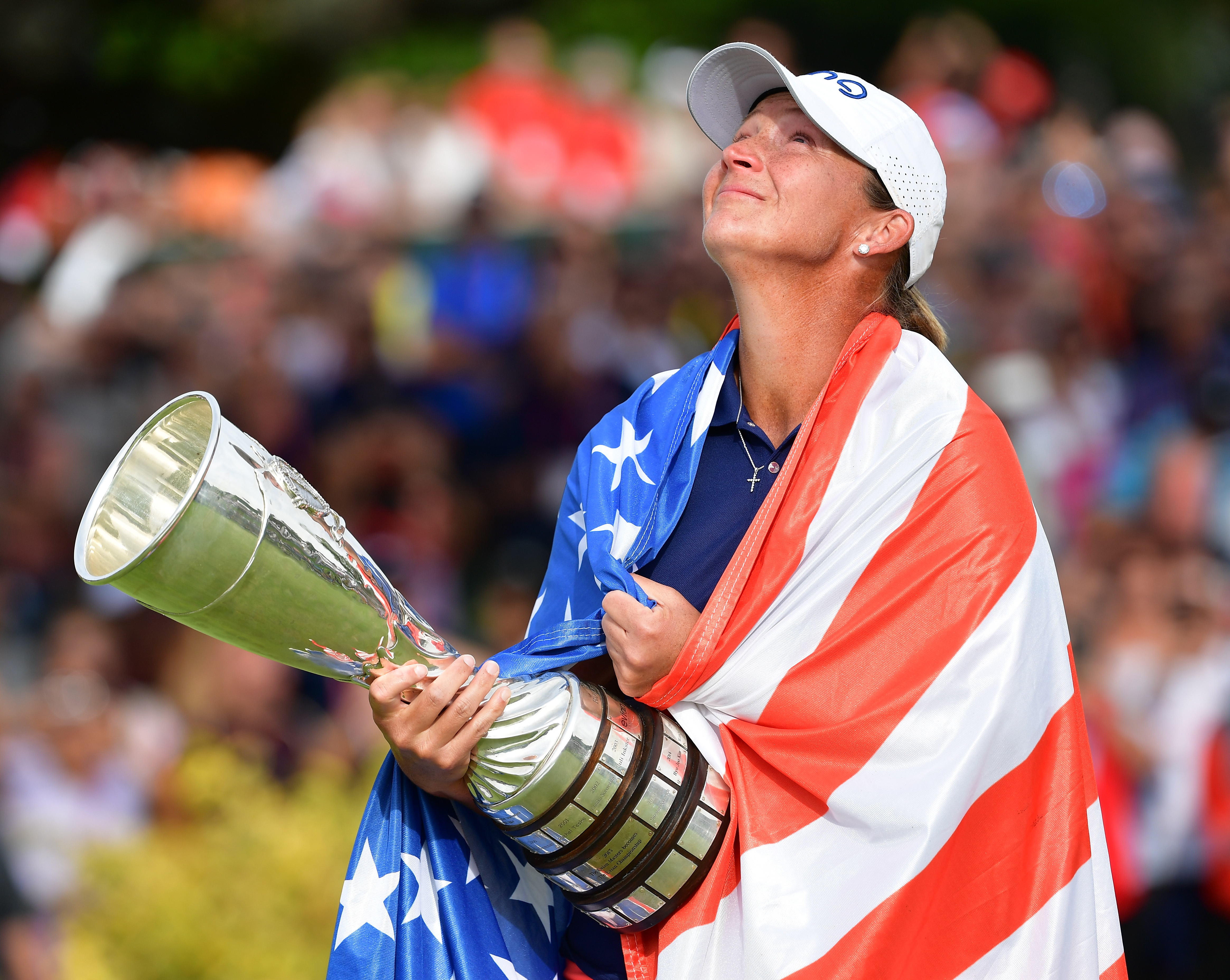 Angela Stanford looks to the sky with tears in her eyes and holding the Evian Championship trophy in 2018