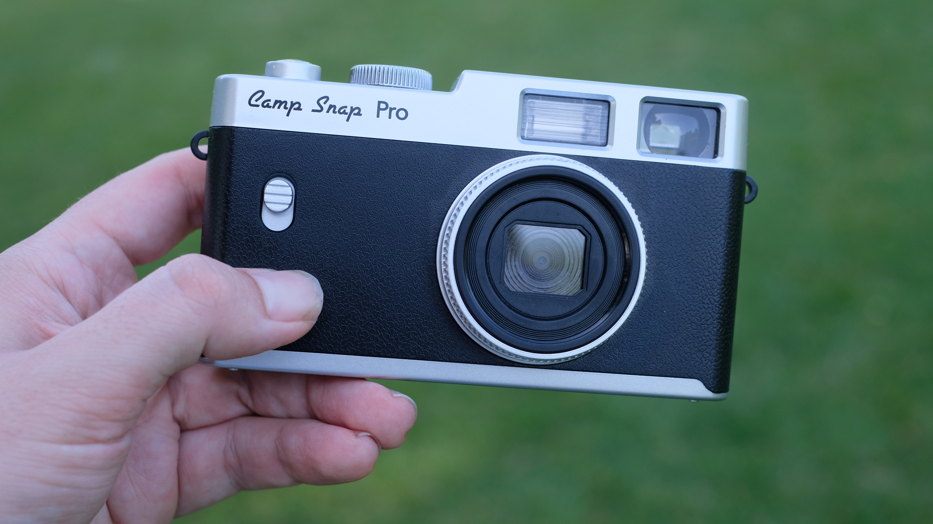Photograph of Camp Snap CS-Pro digital compact camera being held in hand, facing forwards to show lens and front