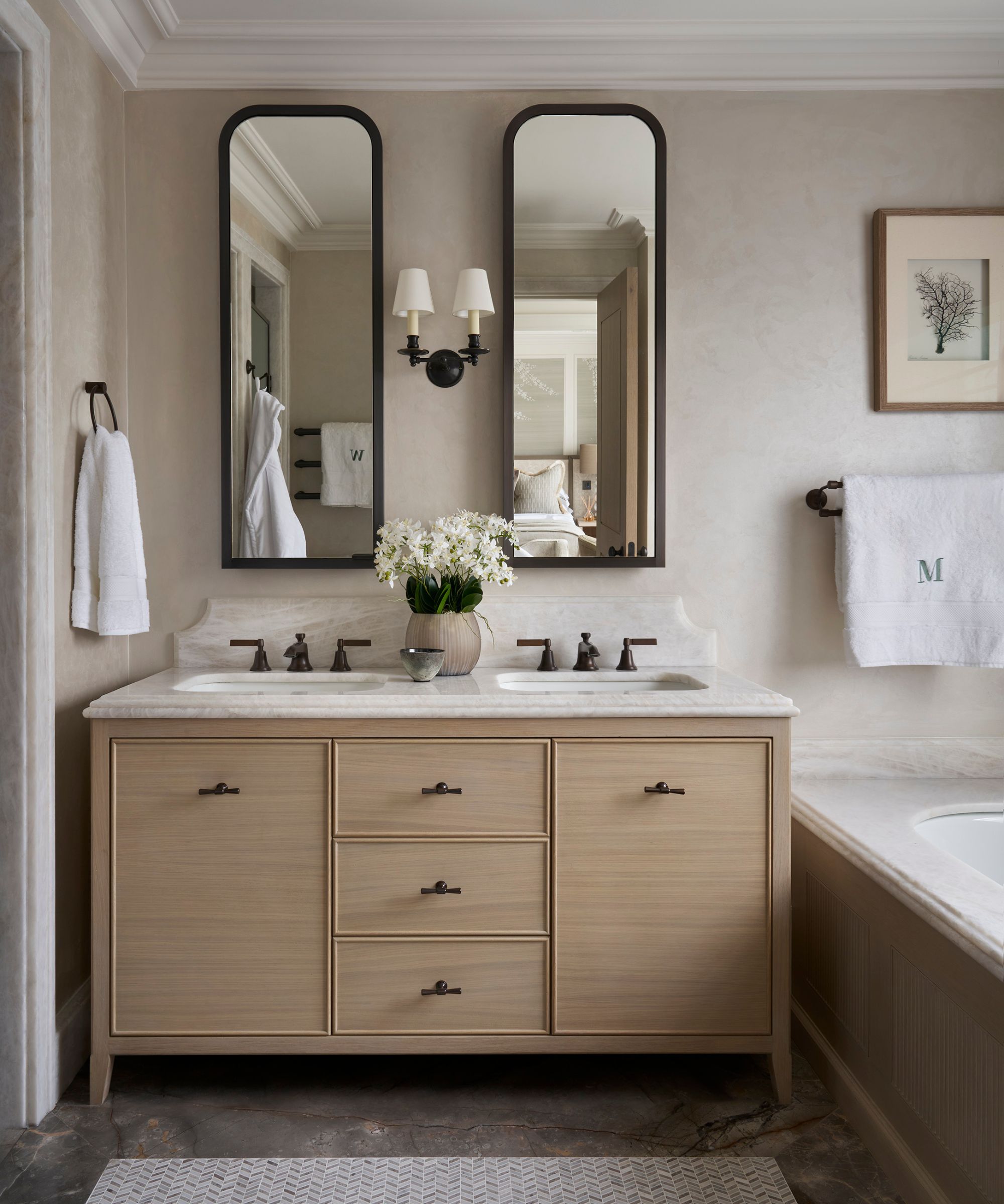 a neutral primary bathroom with a built-in bath and double sink wooden vanity with twin mirrors