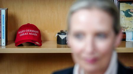 With a Make Germany Great Again baseball cap on display in the background, a blurred close up of AfD co-leader Alice Weidel 