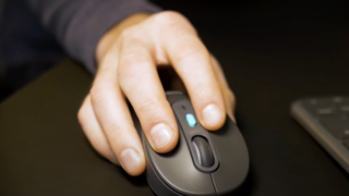 A hand using a Logitech mouse