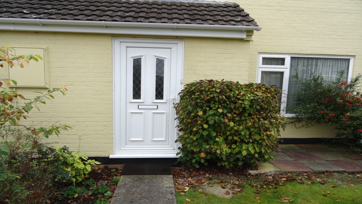 White uPVC door on yellow painted brick house