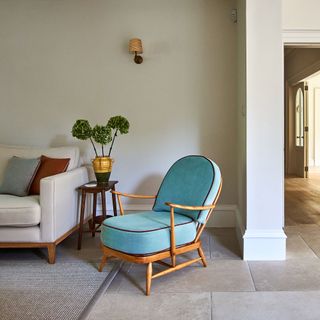 Pale blue armchair with curved cushions in a neutrally painted living room