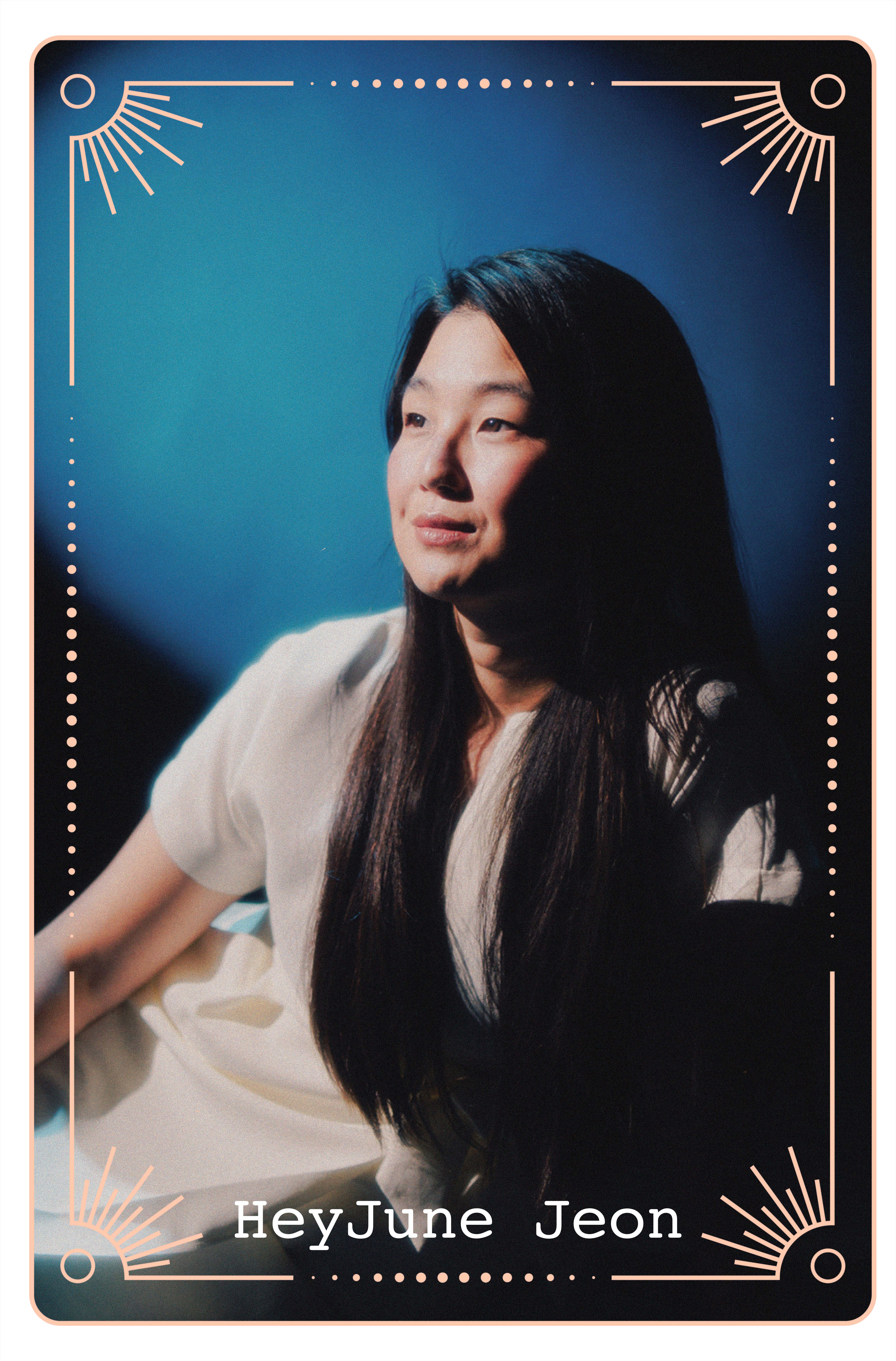 HeyJune Jeon sits in a soft blue-lit setting wearing a cream top.