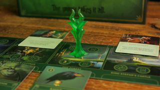The Maleficent mover, board, and cards from Disney Villainous on a wooden table