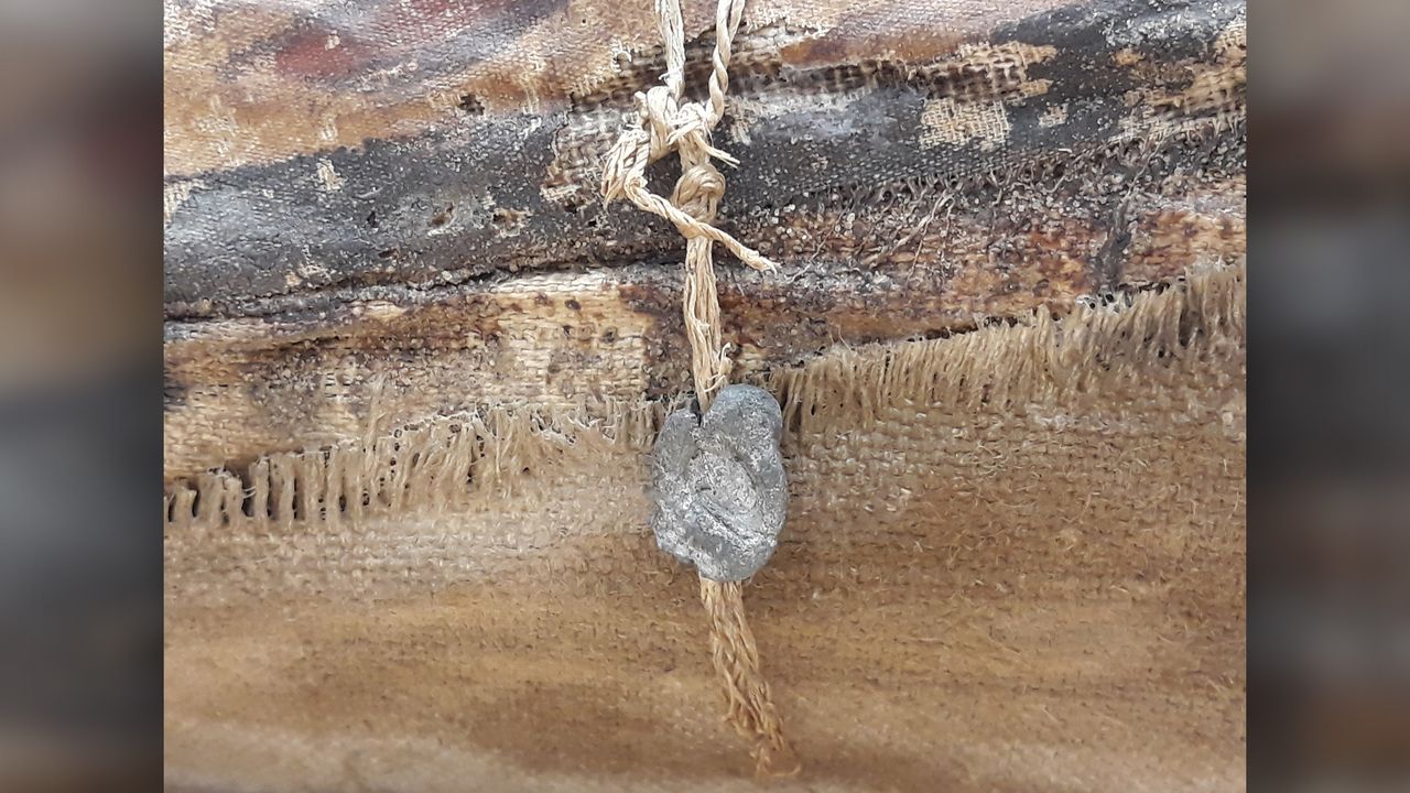 A lead seal on the outside of the male mummy.