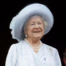 Queen Mother in blue hat and dress celebrating her 100th birthday with daughter Queen Elizabeth II in lavender and grandson Prince Charles at Buckingham Palace