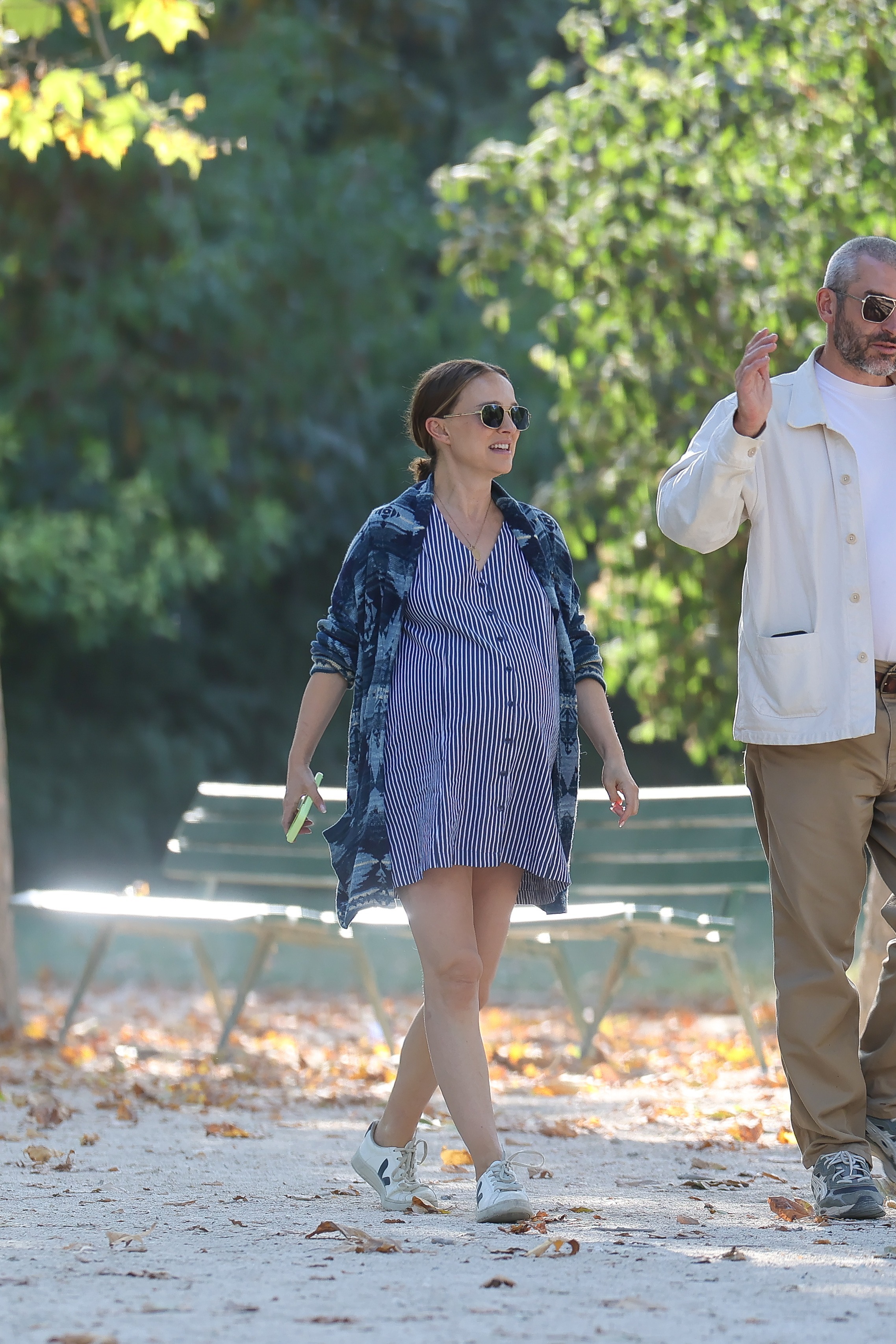 Natalie Portman styled Veja sneakers with a pinstripe maternity dress in Paris