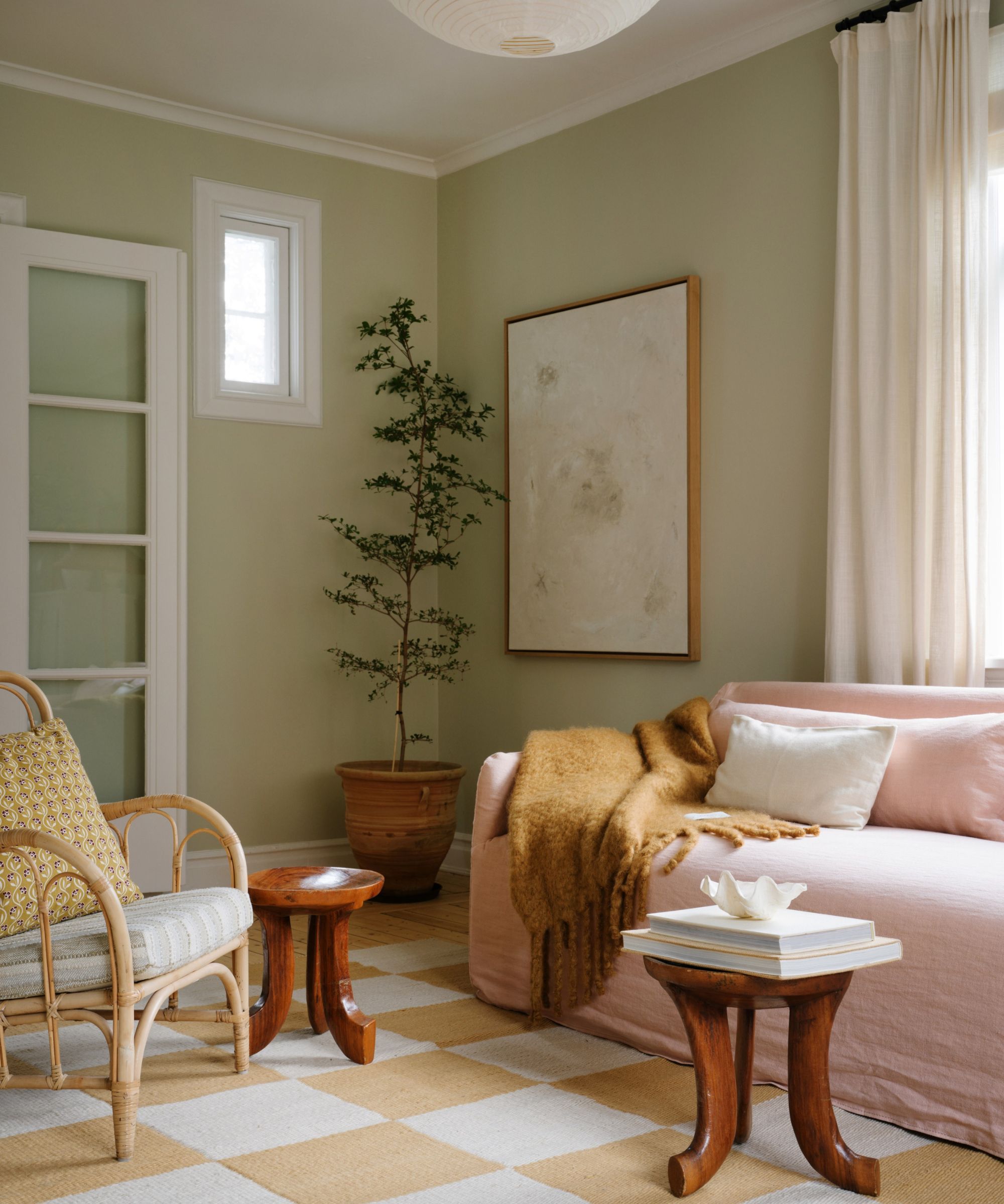 pale green living room with a yellow checkerboard rug and pale pink couch