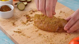 Chicken being seasoned