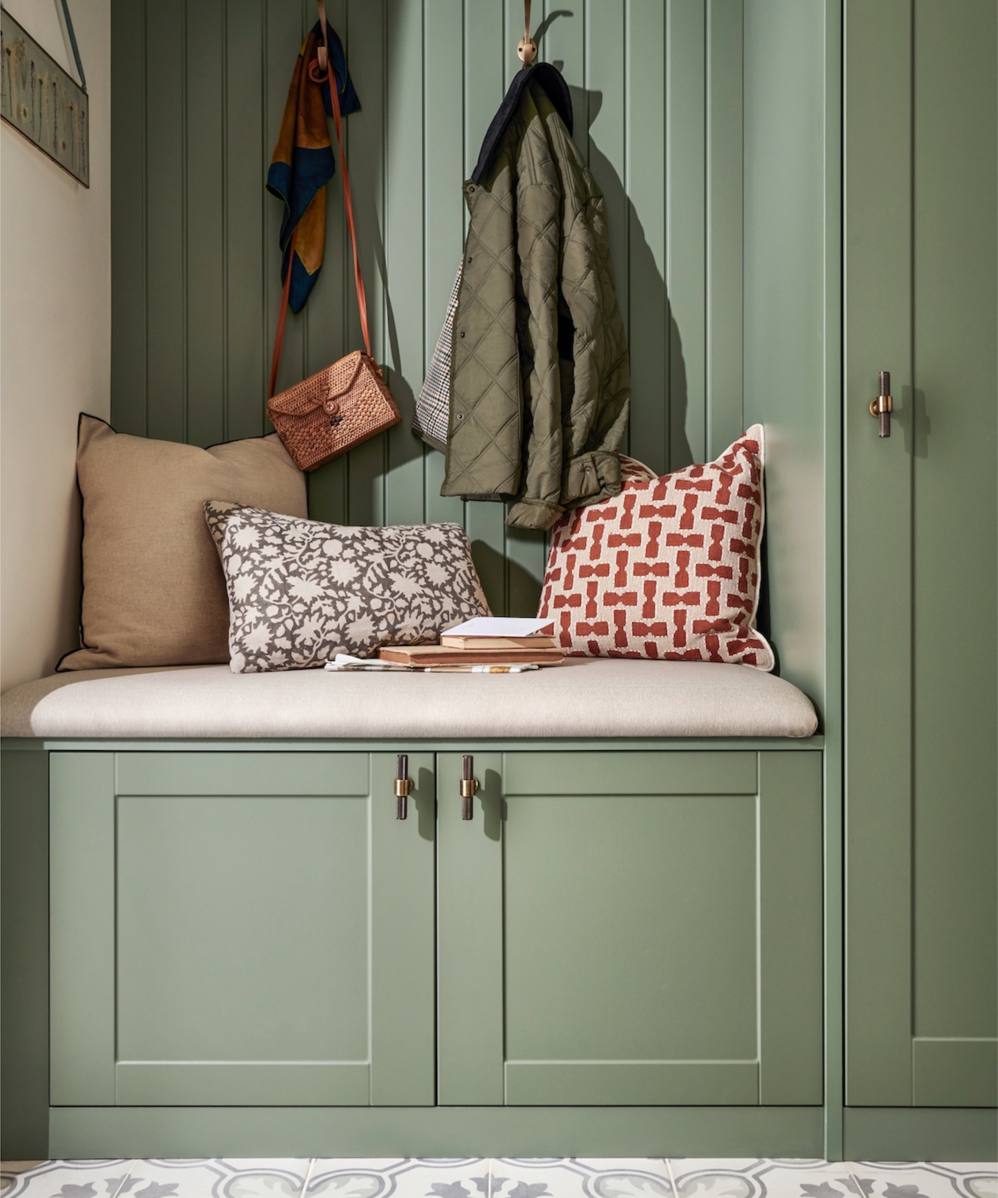 sage green wooden built in hallway storge with seating, cupboards and hooks