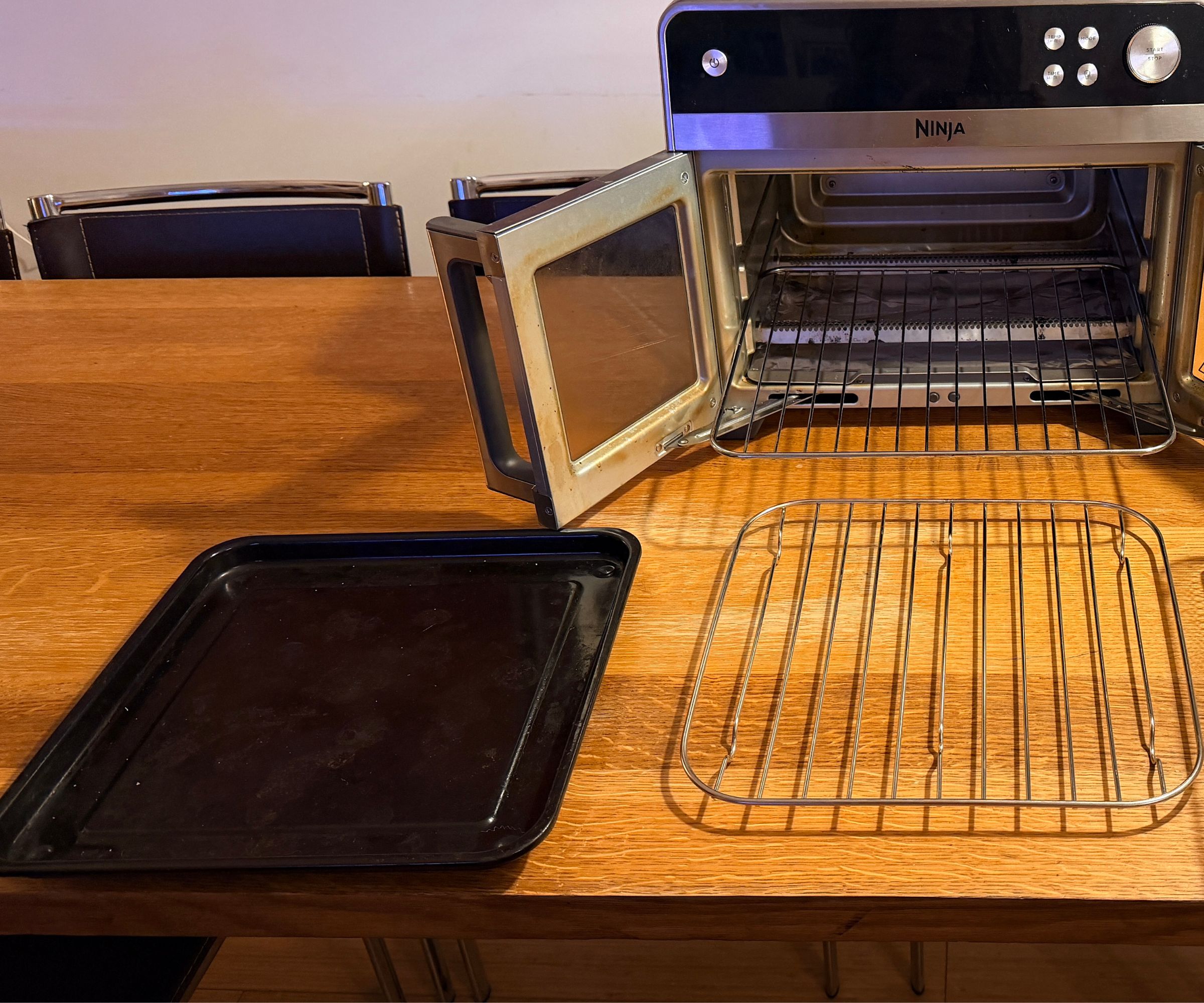 Ninja French Door Premier with a removeable black metal and wire trays on a wooden kitchen counter
