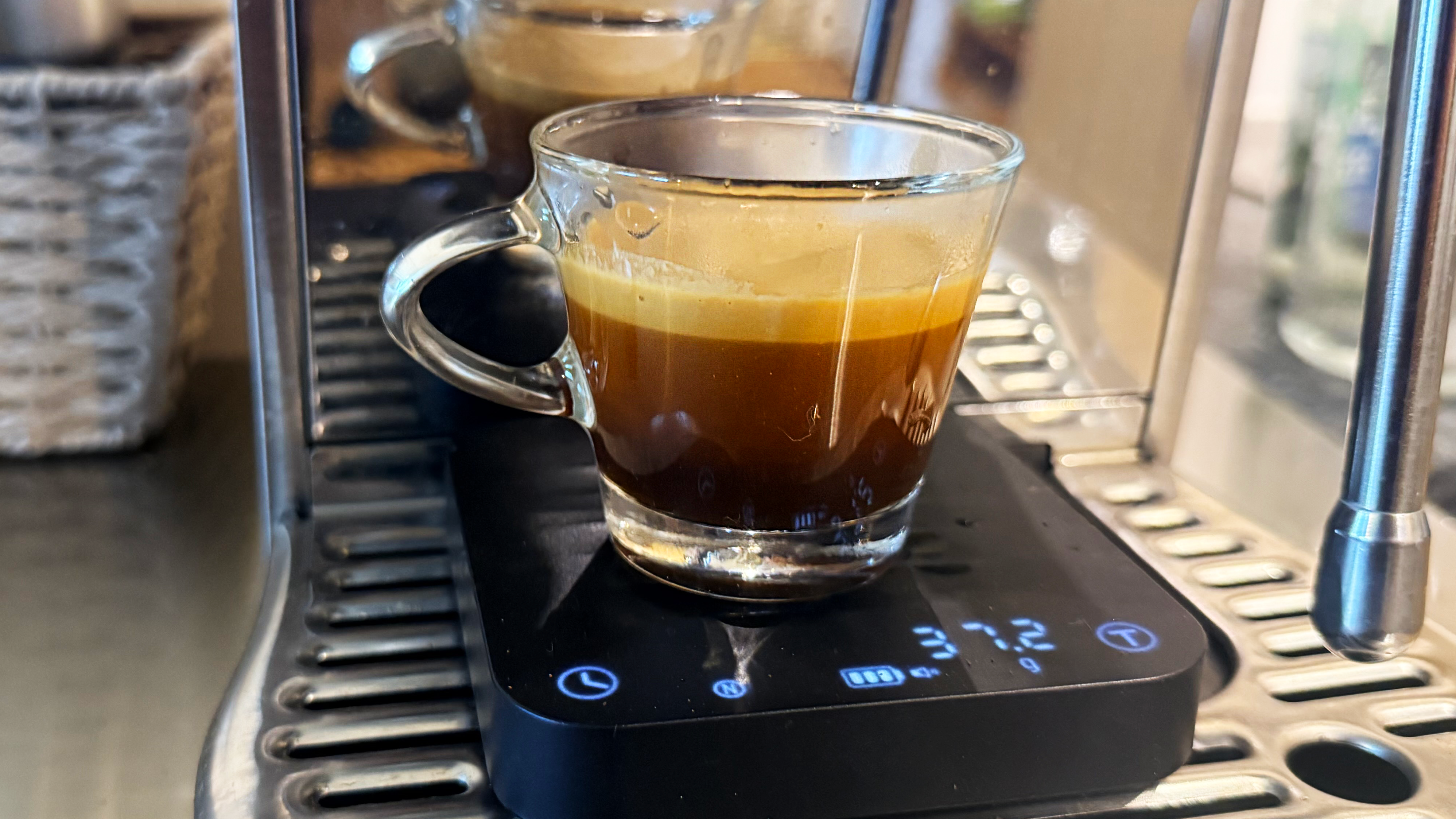 A photo of espresso made on the breville bambino plus espresso machine in a shot glass with the wacaco exagram pro scale