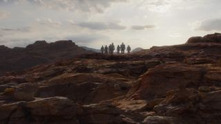 Una foto di gruppo di alcuni Mandaloriani che camminano su un mondo roccioso in The Mandalorian S03