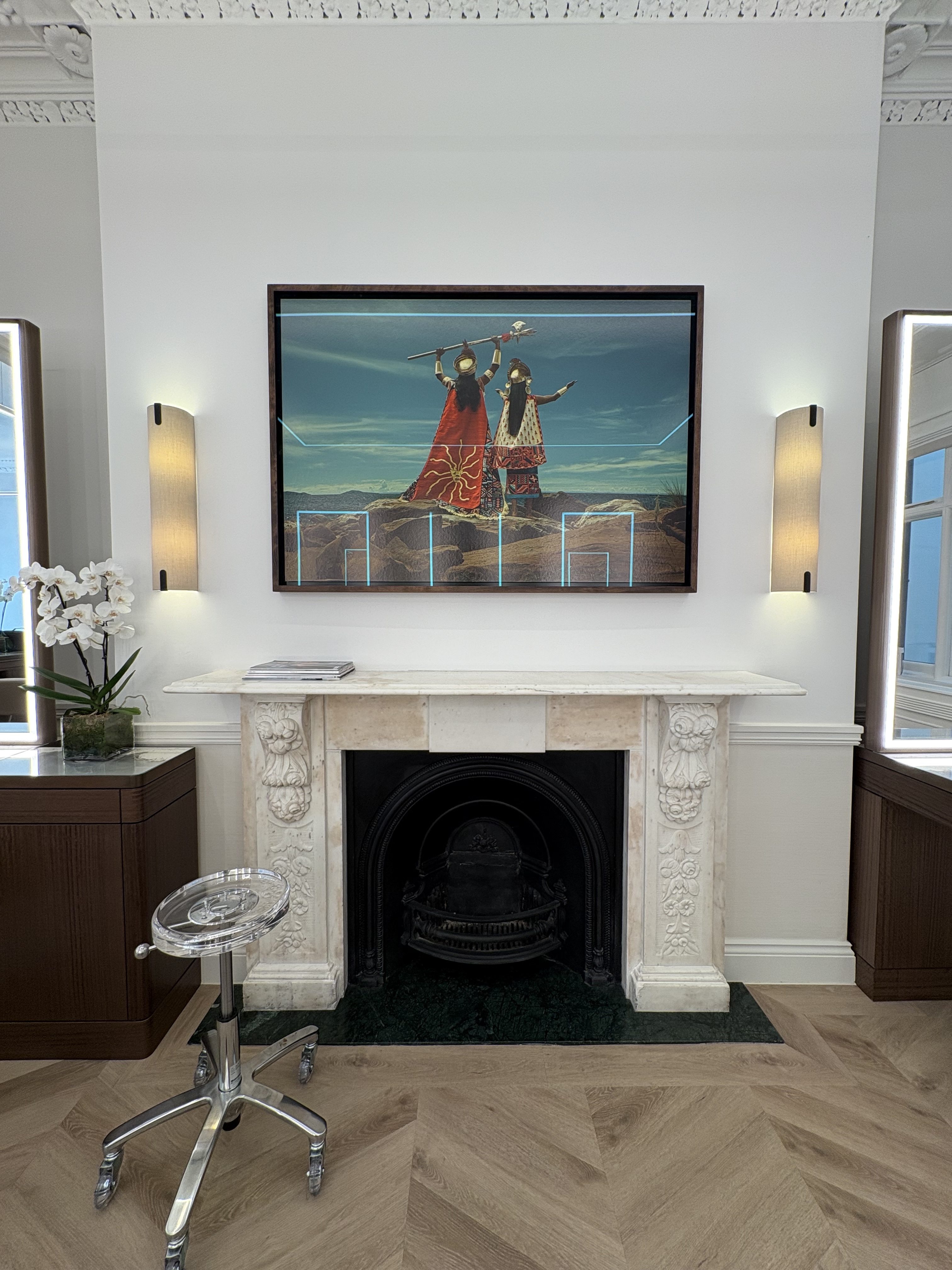 A strikingly lit beauty salon sited within a historical, thoroughly renovated townhouse revives its architectural volumes through contemporary lighting, plush leathery furnishings, and sleek countertops.