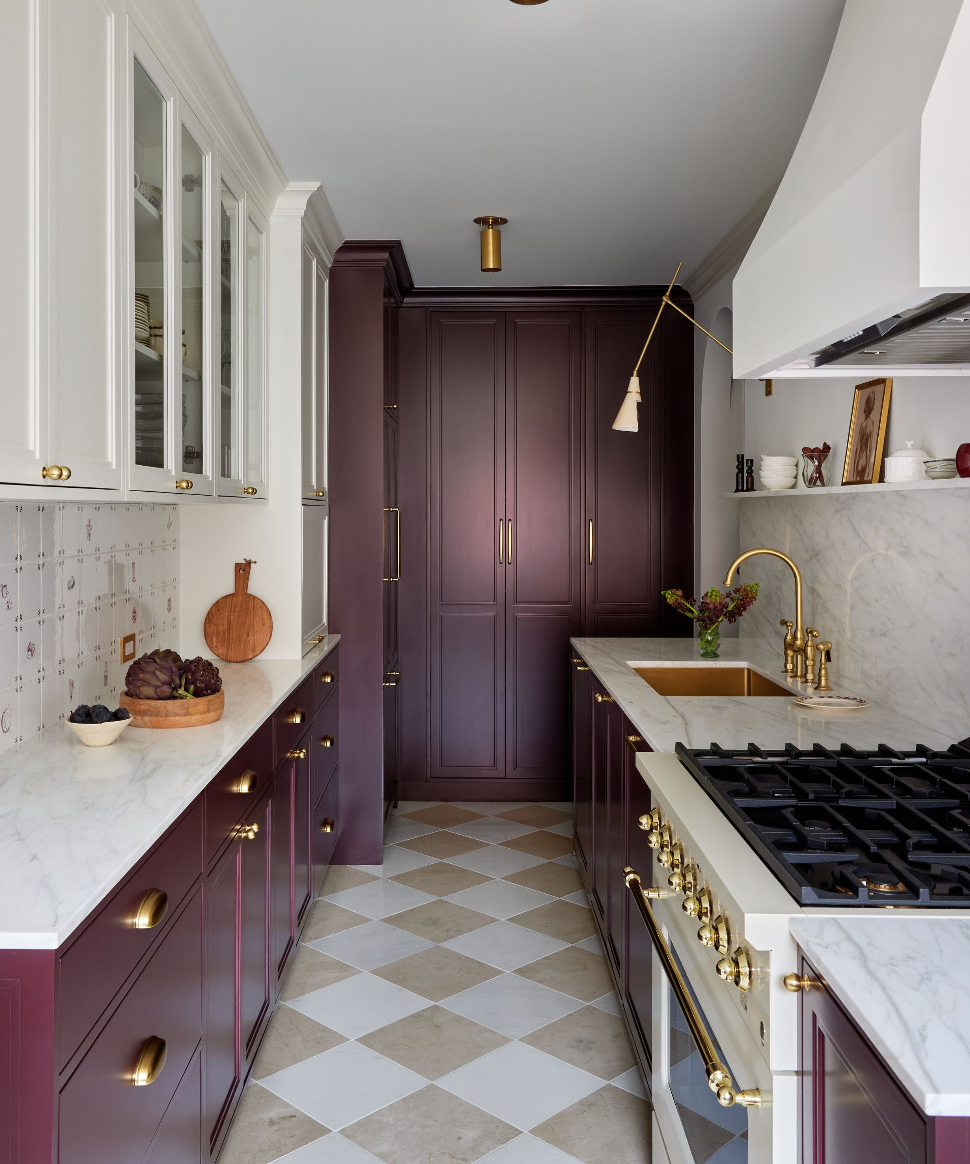 A kitchen with plum cabinets, white walls, and a checkerboard tile floor