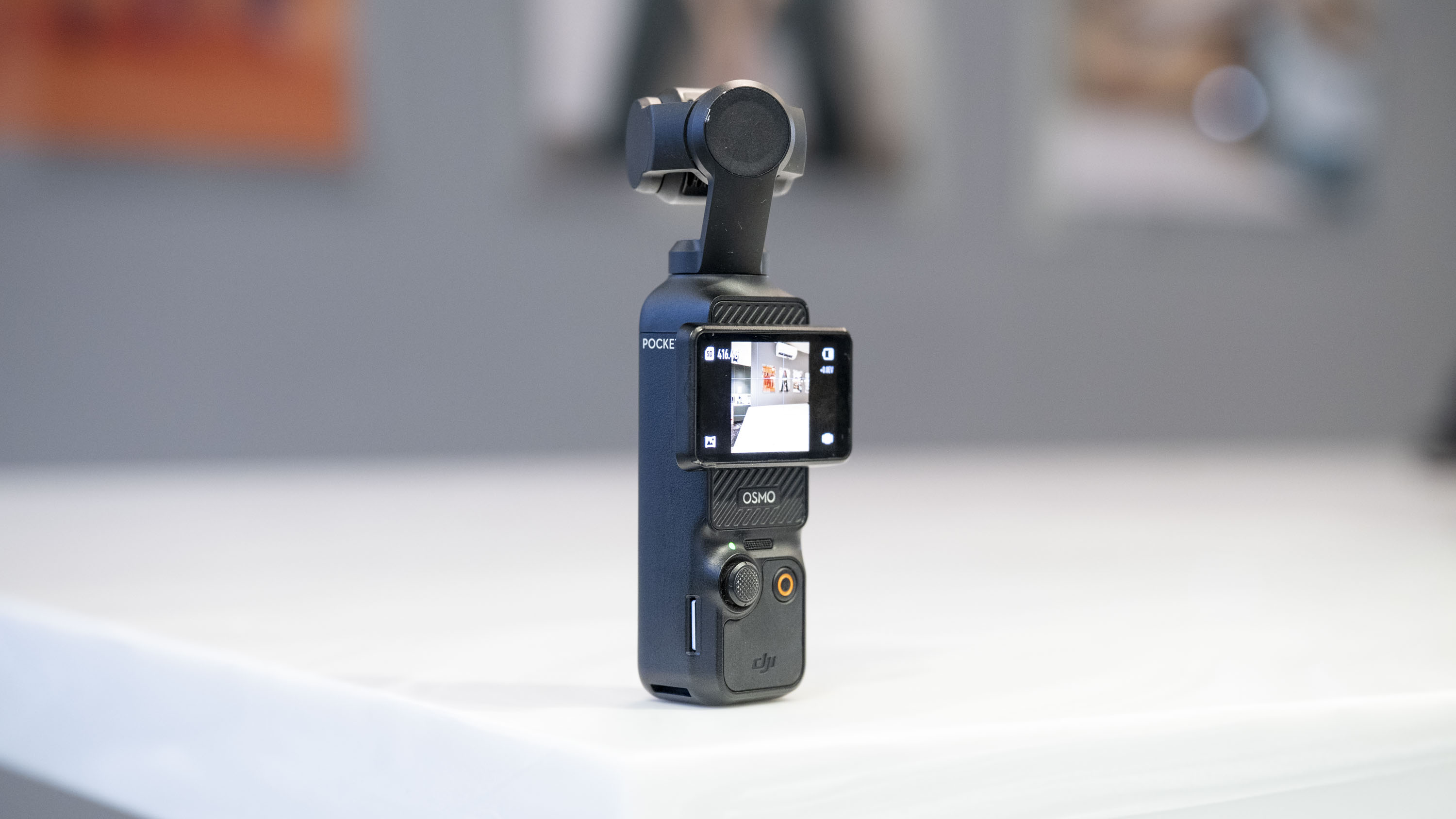 DJI Osmo Pocket 3 vlogging camera stood on a white marble-effect table