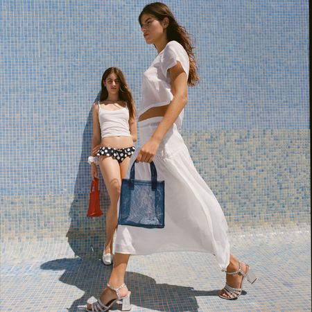 two models wearing the Maryam Nassir Zadeh for J.Crew collection while standing in an empty pool