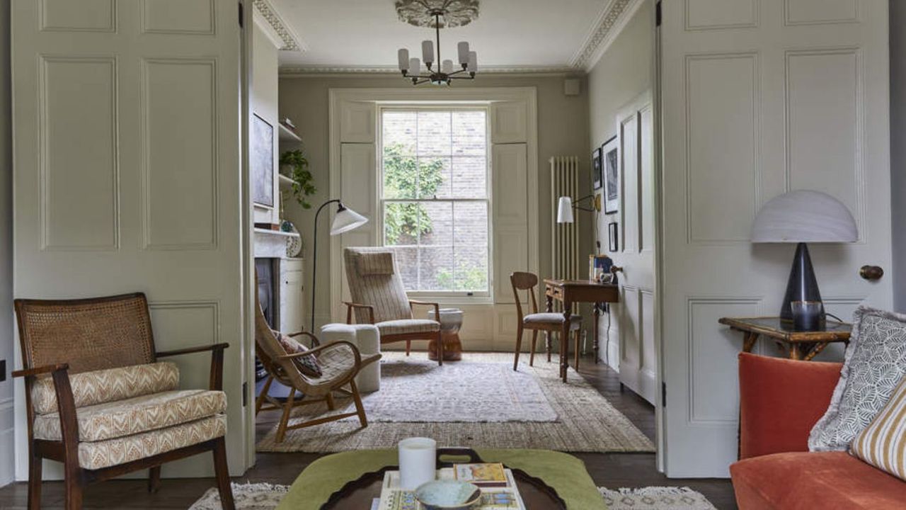 A living room with doors opening into a small room