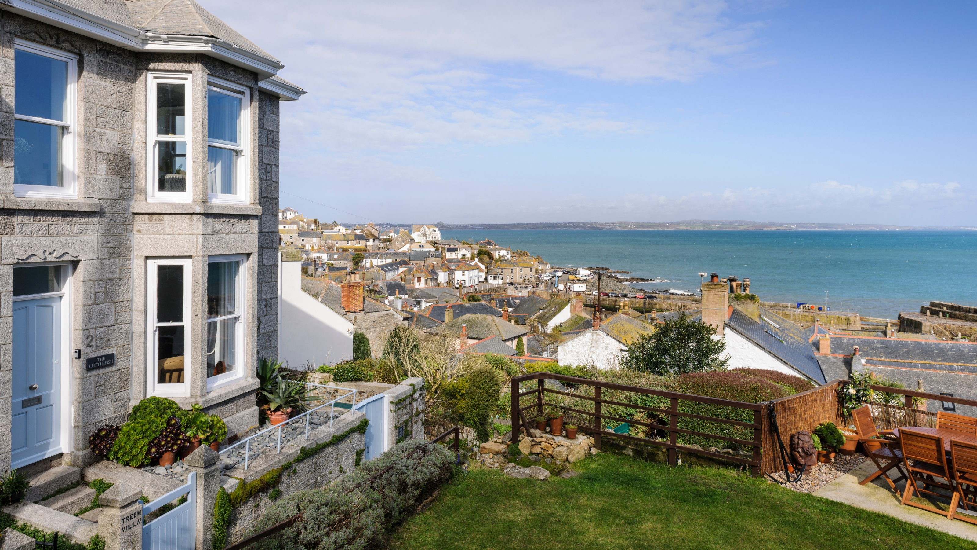 Exterior of house and front garden with garden furniture overlooking the sea.