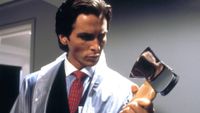 Christian Bale as Patrick Bateman holding an axe during the horror movie American Psycho. 