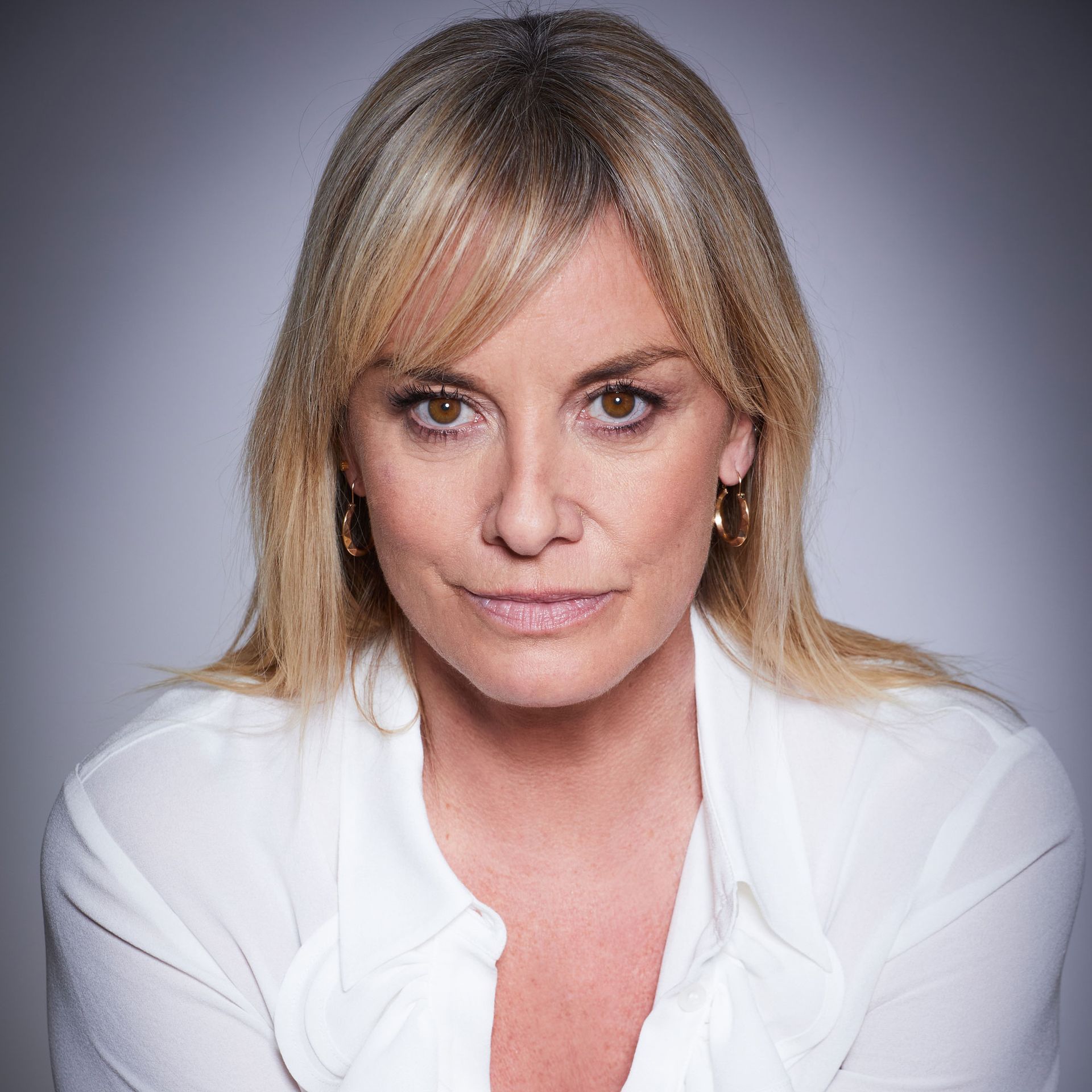 Tamzin looking at camera wearing a white blouse