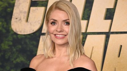 Holly Willoughby is pictured with wavy hair and wearing a black dress at the Celebrity Bear Hunt Launch on Netflix, held at the Odeon West End, London, on 4 February 2025.